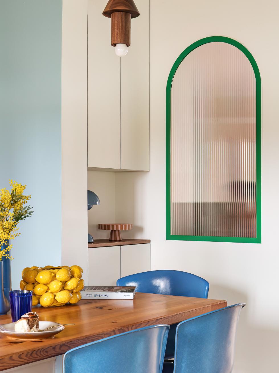 Buntes Esszimmer mit bogenförmigem Fenster.