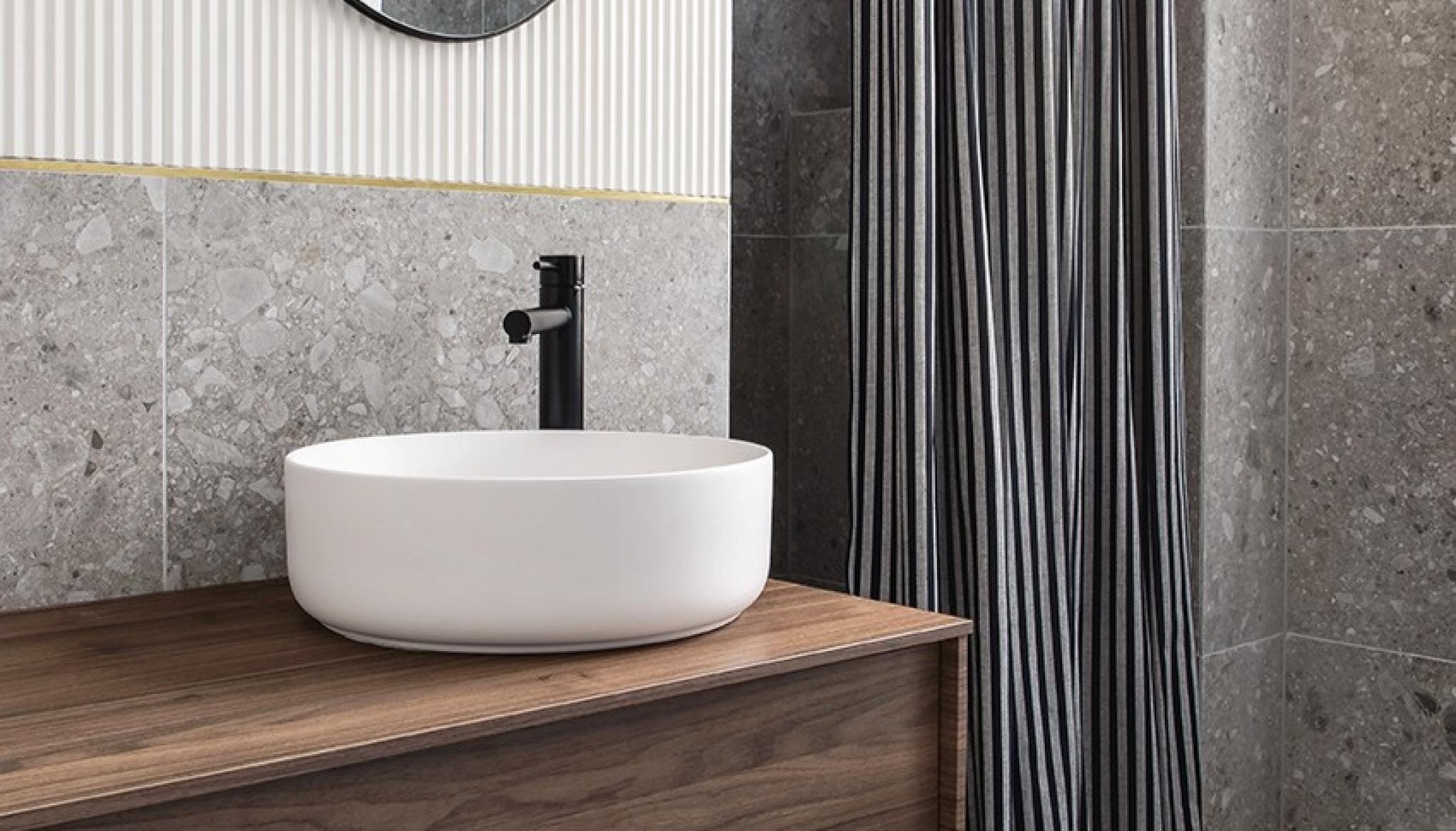 Meuble de salle de bain suspendu en noyer avec carrelage en terrazzo